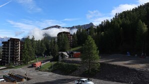 Une zone montagneuse avec des bâtiments, une route et un parking.