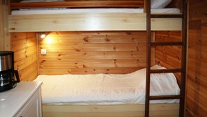 A bunk bed with a ladder, wooden walls, a white mattress, and a small white dresser with a black object on top. - Studio for 4 people in the heart of the resort of Les Orres 1650 (LES ORRES 1650)