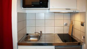 A compact kitchen with a stainless steel sink, a microwave, and a built-in oven. - Studio for 4 people in the heart of the resort of Les Orres 1650 (LES ORRES 1650)