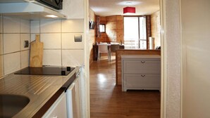 Une cuisine dotée d’un plan de travail en bois, d’un évier et d’un coin repas avec une table et des chaises.