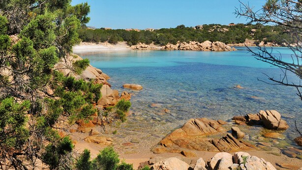 Un paysage côtier caractérisé par une eau turquoise cristalline, des rivages rocheux et une végétation luxuriante.