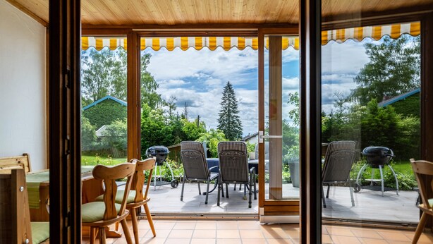 A patio with outdoor furniture, a grill, and a view of a green landscape. - Köberich Apartment with Mountain View, Private Terrace and Large Garden (Waging am See)