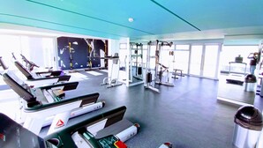 A gym with various exercise equipment, a treadmill, and a Reebok treadmill.
