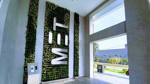 A modern interior with a large wall-mounted sign, a tiled floor, and a view of the outside.