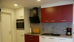 A modern kitchen with a built-in oven, a sink, and a coffee maker. - Holiday Home 'Am Kiefernweg 17' with Private Terrace (Schwielochsee)