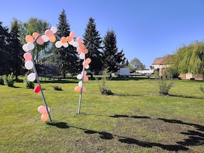 Ett grönområde utomhus med en båge formad av ballonger.