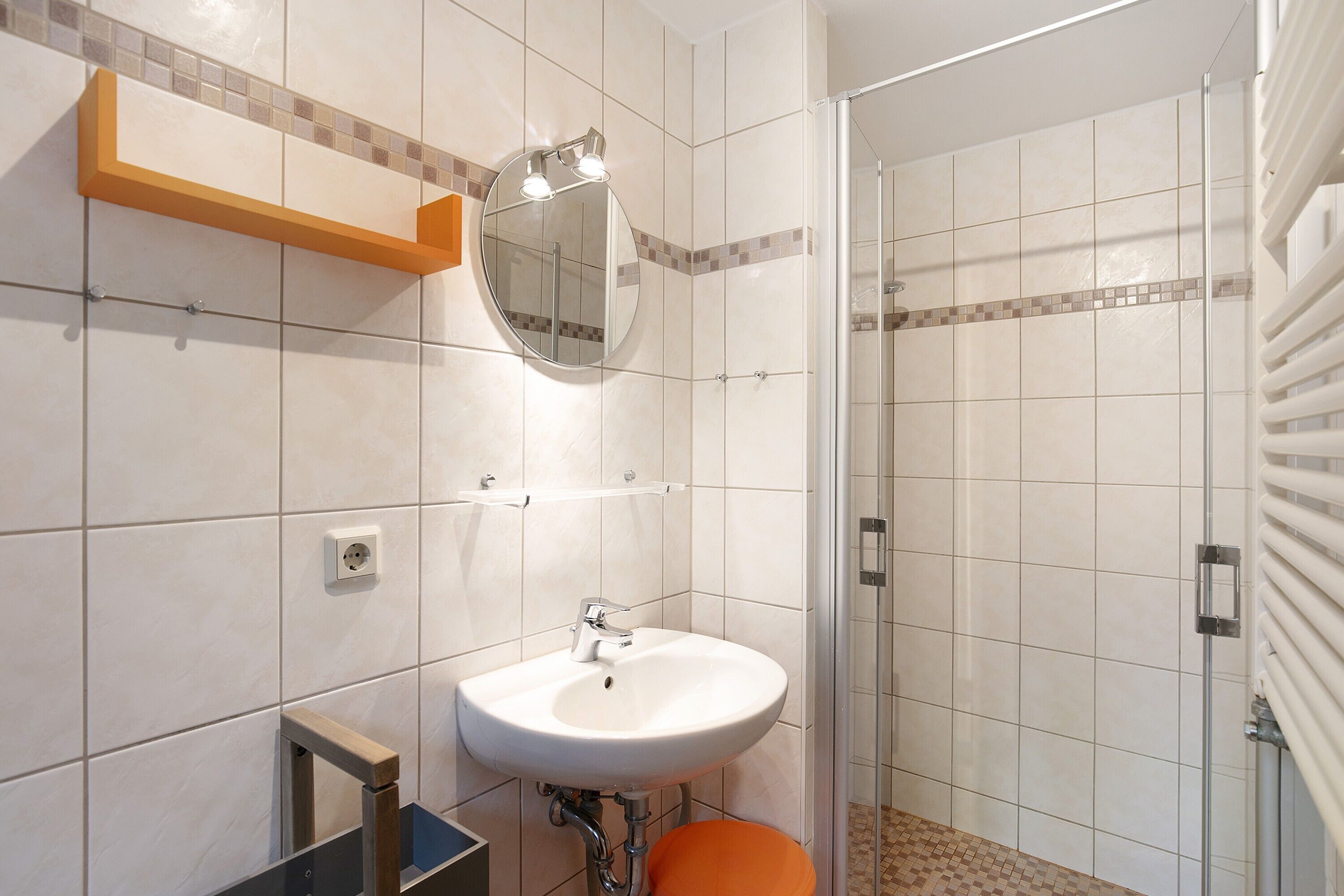 Une salle de bain avec un lavabo, un miroir et une douche.