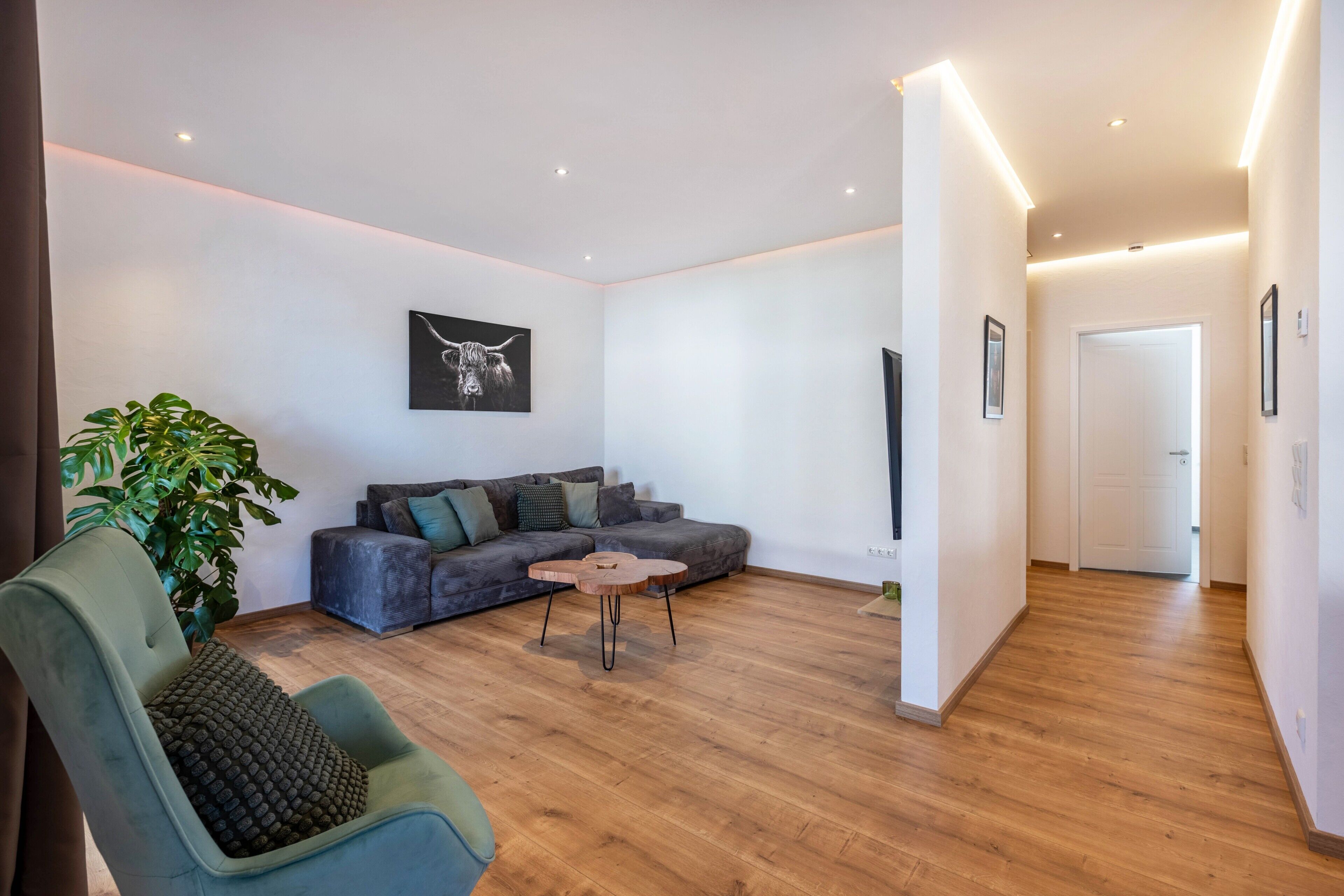 Una sala de estar moderna con un sofá, una mesa de centro y una planta.