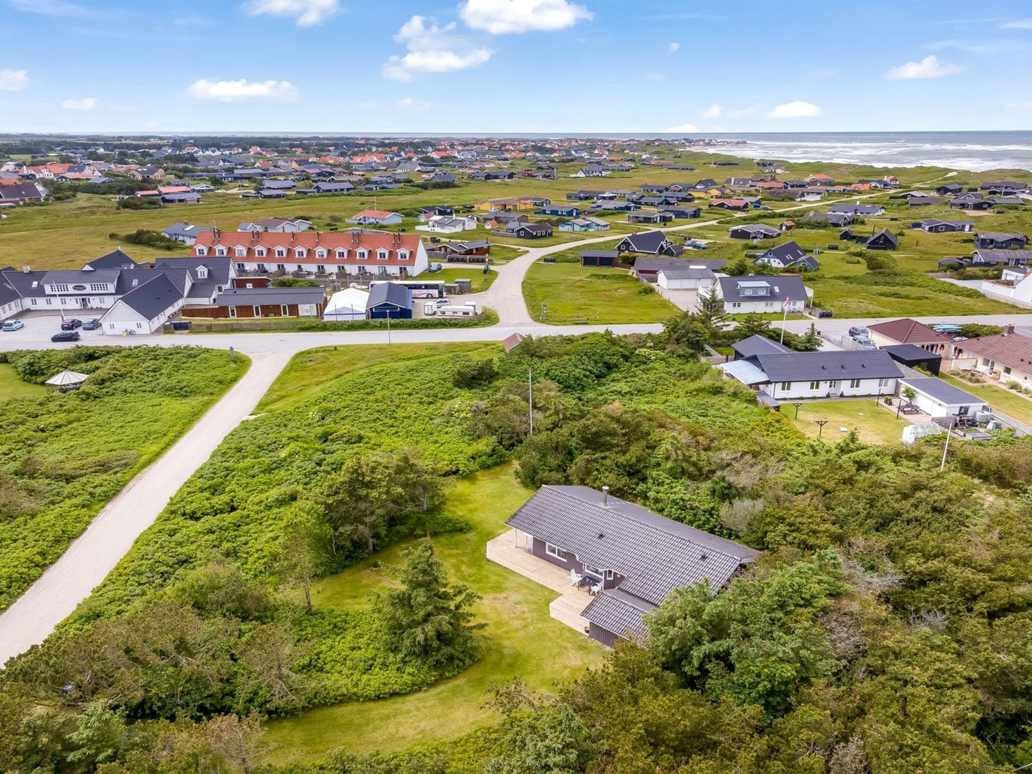 Vista aérea de una zona residencial con casas, carreteras y una costa.