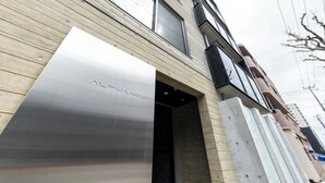 A building with a wooden facade and a large metallic entrance door. - NOBLE 302 (Sapporo)