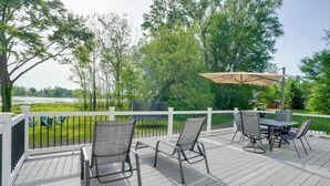 A deck with outdoor furniture, a table, and chairs. - Lakefront Home in Hartford: Hot Tub, Kayaks & Dock (Hartford)