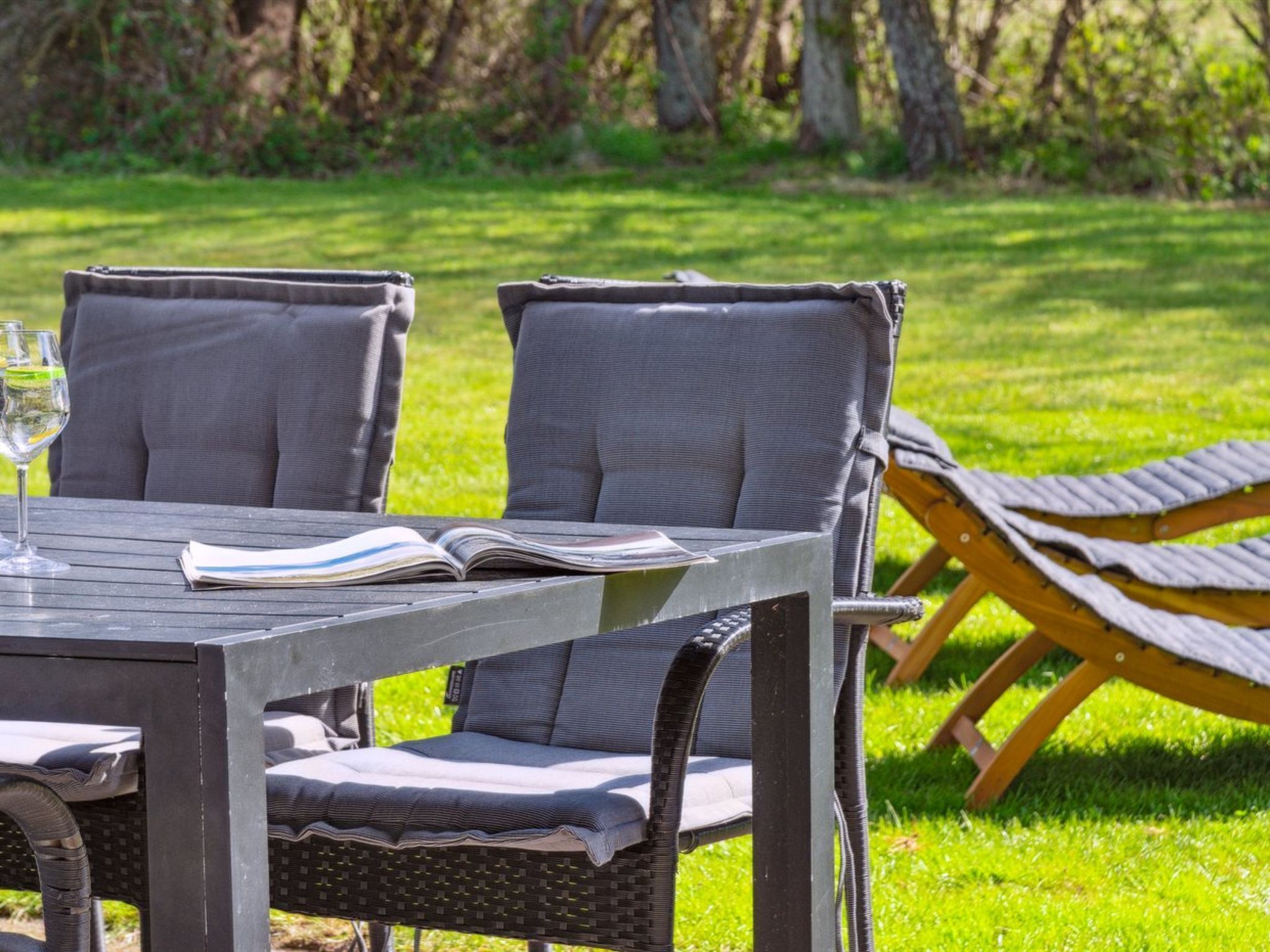 Une table en bois, deux chaises et un livre ouvert.