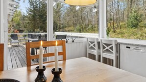 Een eethoek met een tafel, stoelen en een kaarsdecoratie.