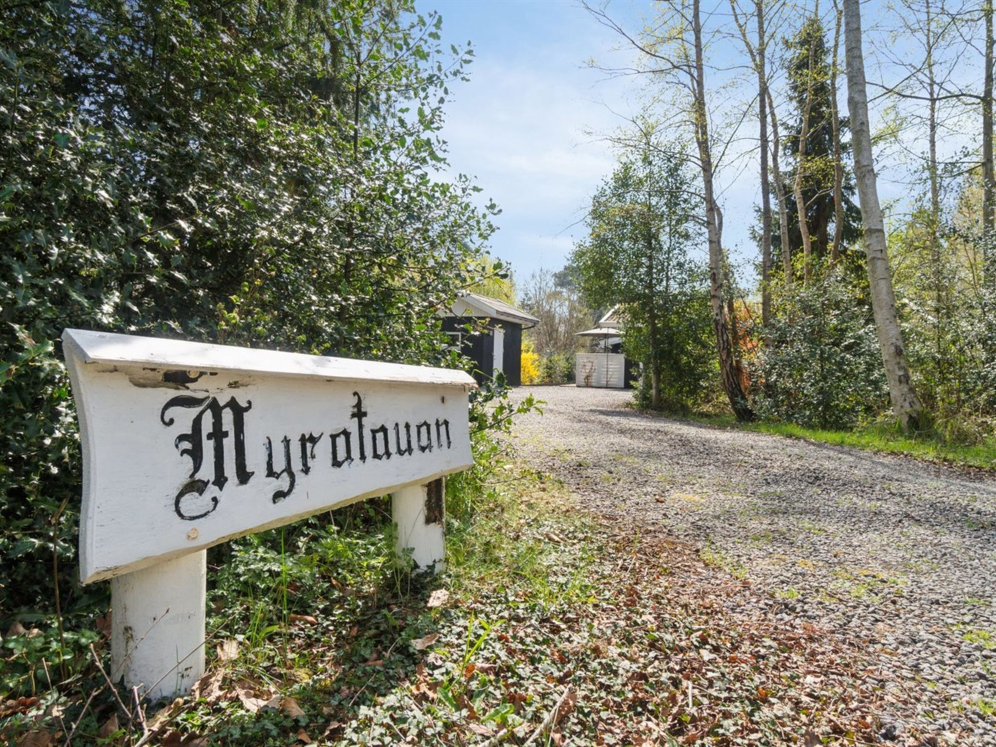 A gravel path leading to a building with a sign reading "Myratouan".