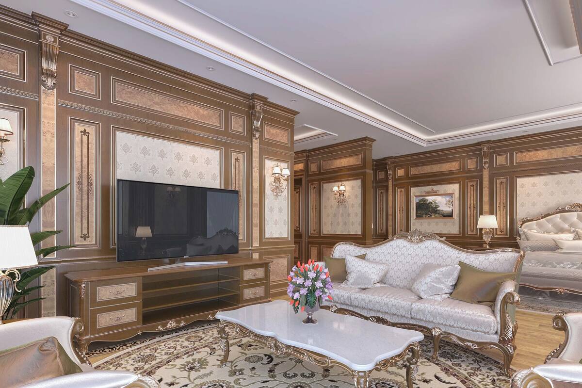 A luxurious living room with a large flat-screen TV, ornate wall paneling, a patterned rug, and elegant furniture.
