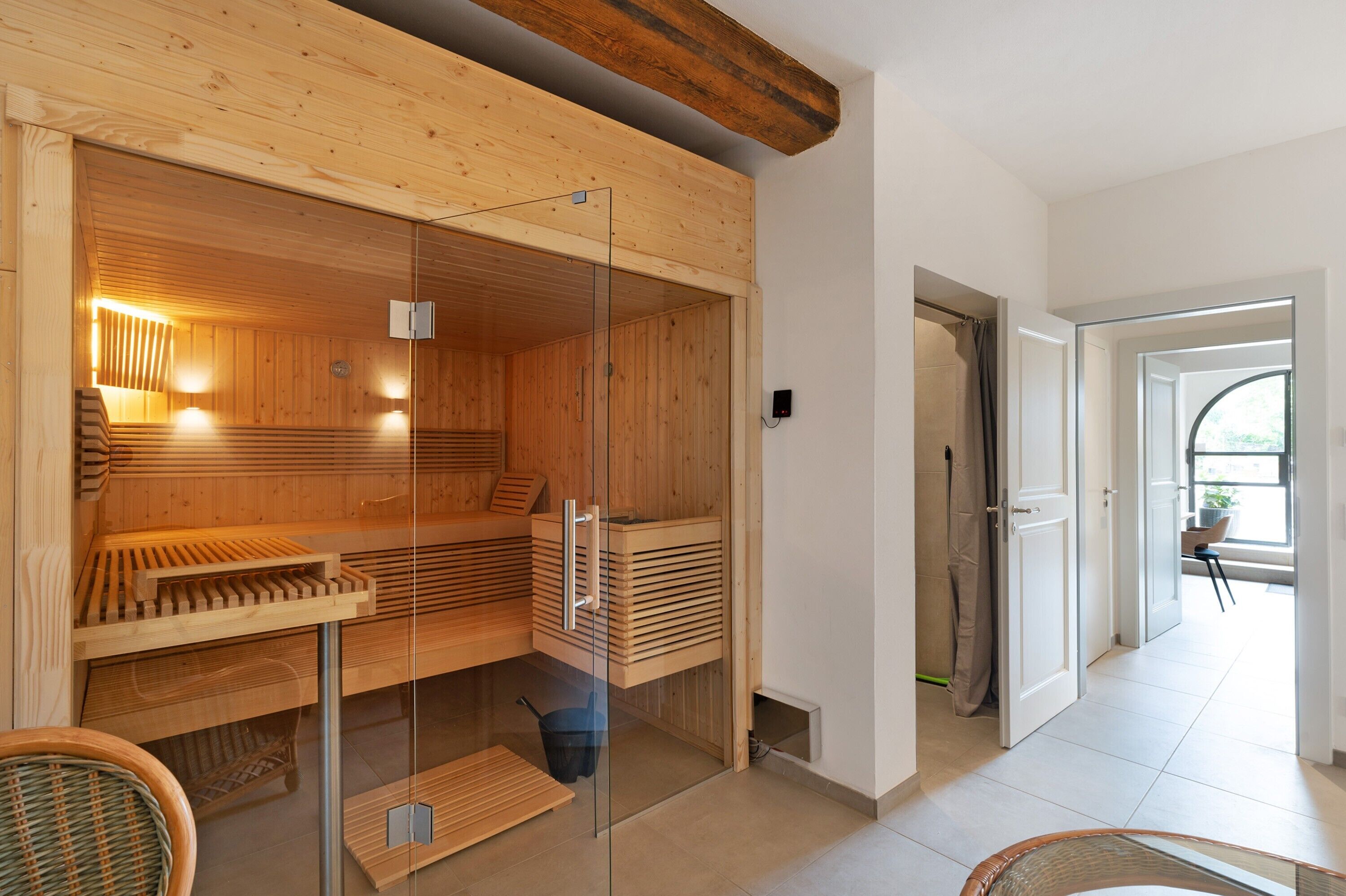 A sauna with wooden benches, glass doors, and a modern design.
