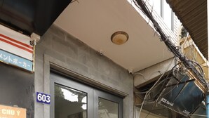 A building entrance with a glass door, a number '603' sign, and steps leading up to the door. - HoLo Kim Ma Hanoi (Hanoi)