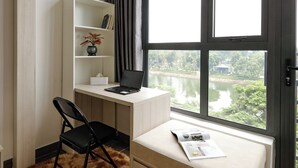 A modern bedroom with a large window, a desk, a chair, a bed, and a bookshelf. - HoLo Kim Ma Hanoi (Hanoi)