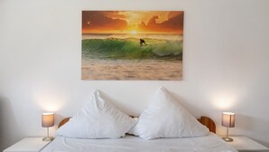 Un dormitorio con una cama, almohadas y lámparas de noche.