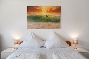 Una camera da letto con un letto, cuscini e lampade da comodino.