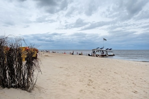 Una spiaggia con una postazione di salvataggio, una piccola barca e una battigia sabbiosa.