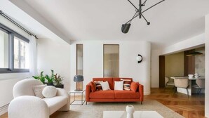 A modern living room with a sofa, a coffee table, and a lamp.