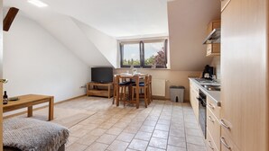 A compact kitchen with a dining area, a television, and a window with a view. - Apartment 'Ferienwohnung Thomée' with Terrace and Wi-Fi (Looft)