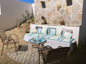 An outdoor seating area with a sofa, chairs, and a table.