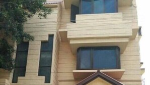 Un immeuble à plusieurs étages, doté d’un toit plat et d’un élément architectural triangulaire bien visible à l’avant.
