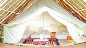 A tent with a bed, pillows, and a vase. - Tawaen Caza Sky Camping (Koh Lan)