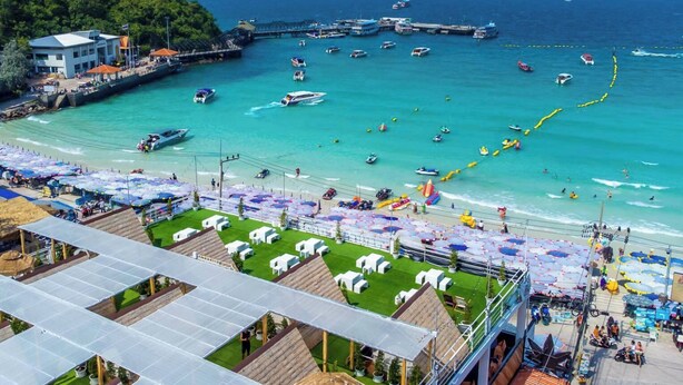 A coastal area with a marina, beach umbrellas, and a view of the sea. - Tawaen Caza Sky Camping (Koh Lan)