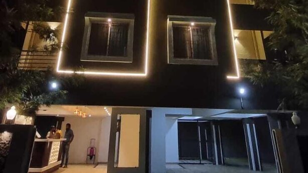 Un edificio con un cartel que dice "AR RESIDENCY EXECUTIVE ROOMS" de noche.
