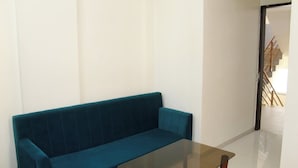Una sala de estar con un sofá color turquesa y una mesa de centro de vidrio.