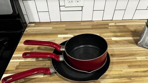 A kitchen with a wooden countertop, a red pan, and a matching pan lid. - Serene Country Cottage (Woodbridge)