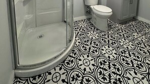 A bathroom with a shower, toilet, sink, and patterned floor. - Serene Country Cottage (Woodbridge)