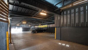 Un estacionamiento interior con un coche negro aparcado en un espacio reservado.