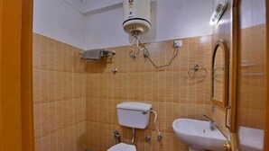 Un baño pequeño con inodoro, lavamanos y perchero para toallas.