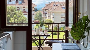 Un balcon donnant sur des immeubles d’habitation et un jardin.