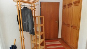 Un passadís amb un estendal de fusta, una porta i un armari.