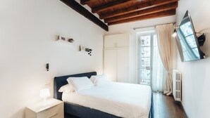 A bedroom with a bed, nightstand, and a mounted TV. - La dimora di Brera (Milan)