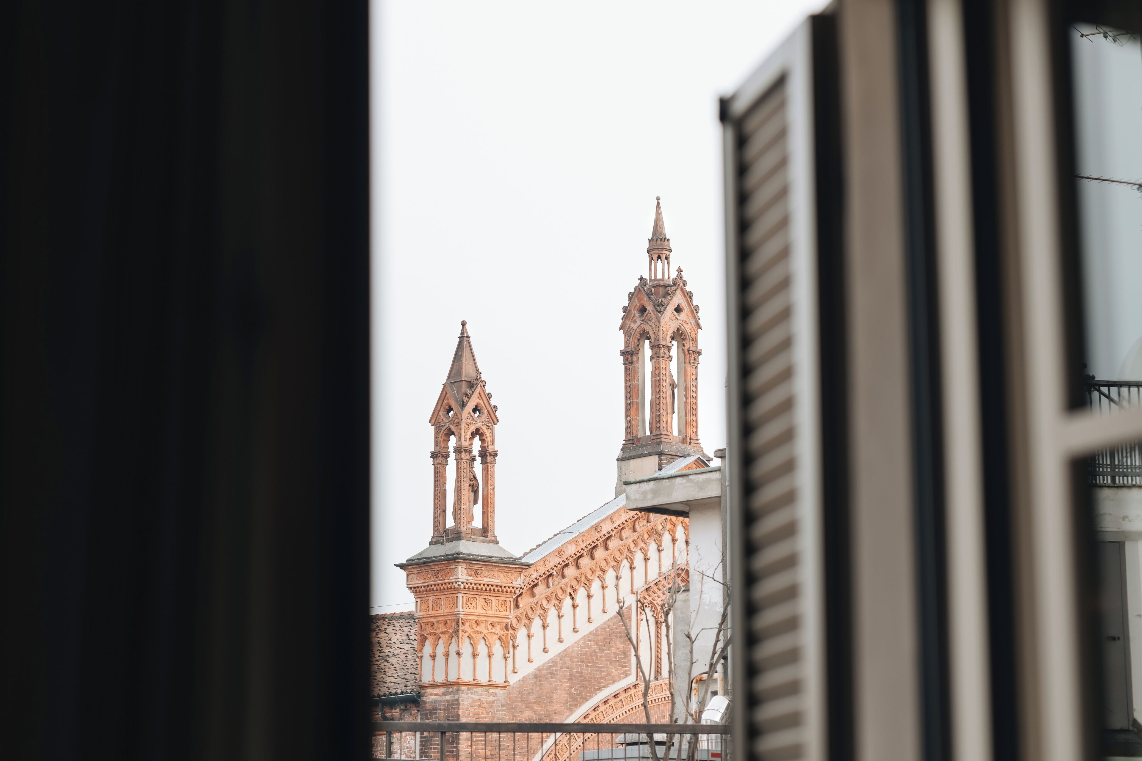 A view of a historic building with intricate architectural details and two prominent towers.