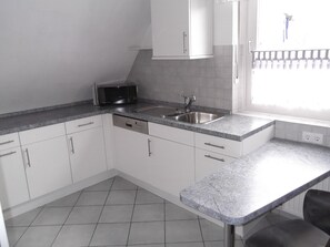 Een koelkast, een magnetron, een kookplaat, een vaatwasser