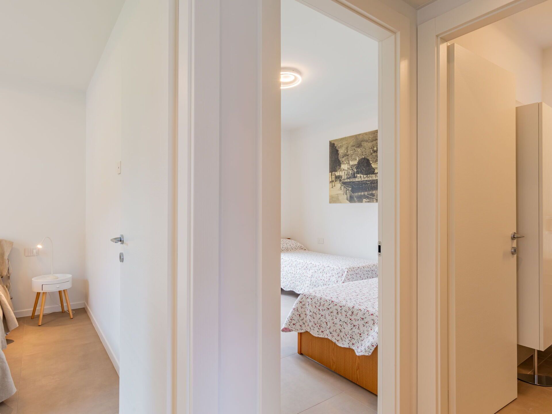 Une chambre à coucher avec un lit, une petite table de chevet et un tableau accroché au mur.