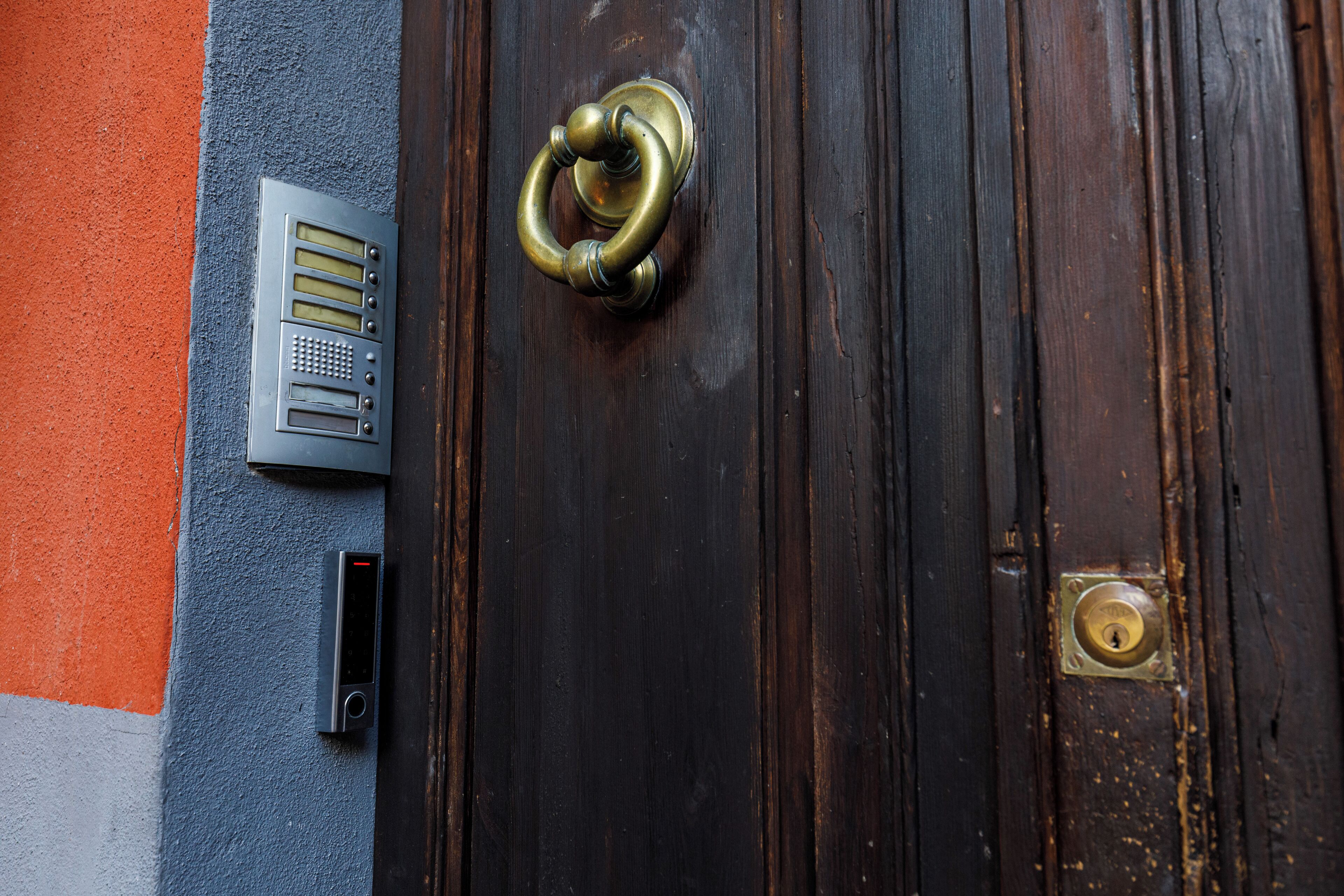 Una puerta de madera con un aldabón de latón y una cerradura.