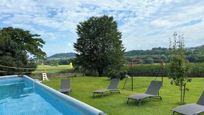 An outdoor swimming pool with a grassy area, lounge chairs, and a tree. - House with swimming pool and bowling green at the foot of the Pyrenees (Asson)