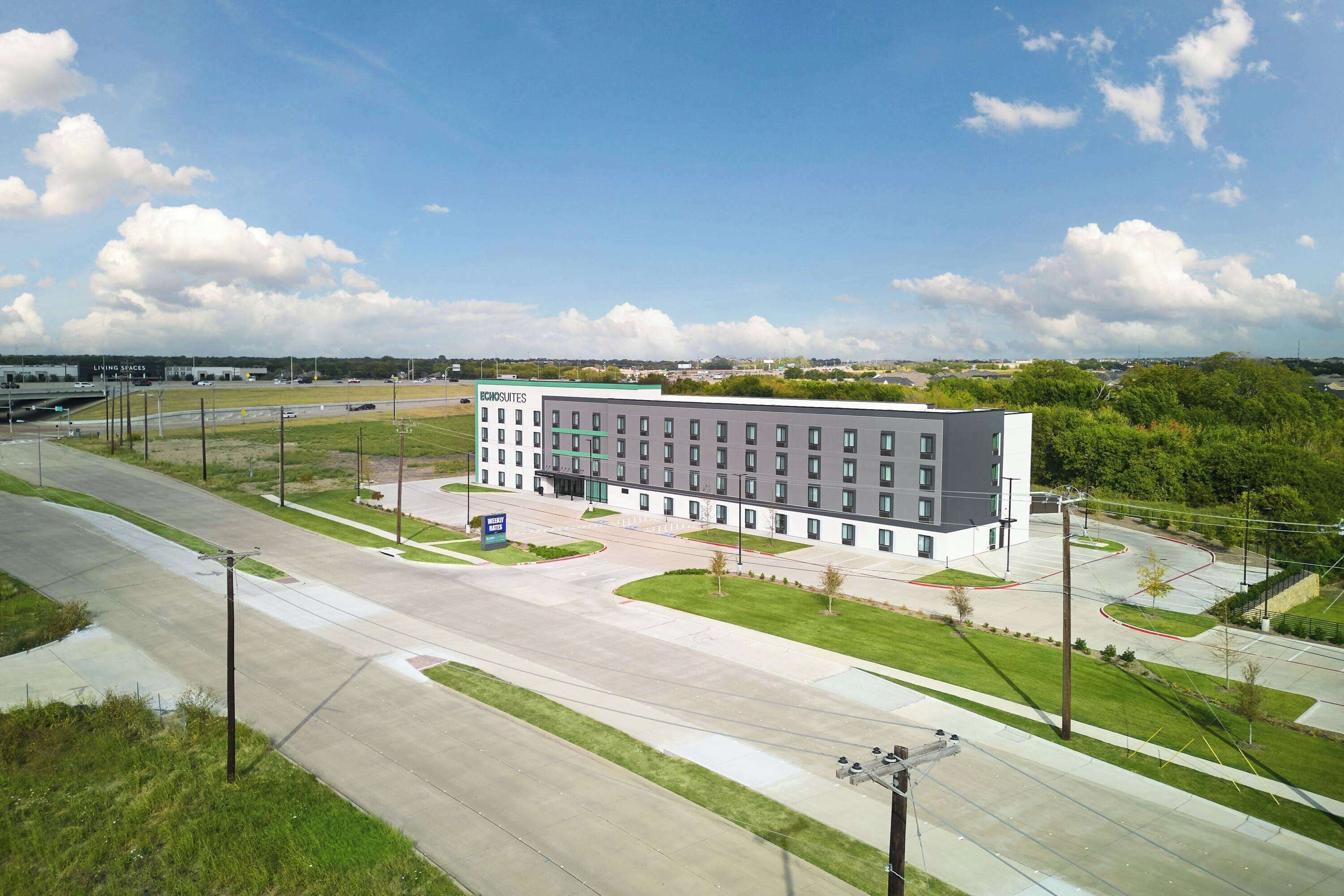 Un hôtel moderne doté d’une cour intérieure, de plusieurs étages et d’un espace de stationnement.
