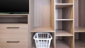 A wooden wardrobe with two drawers and a hanging basket.