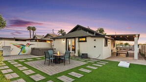A backyard with a patio, artificial grass, a barbecue, and a mural. - Charming House & Cottage in Downtown Phoenix (Phoenix)