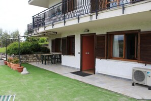A two-story building with a balcony, a door, and a window.