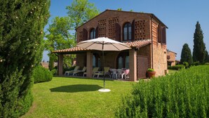A brick house with a patio area, outdoor seating, and a garden. - Tuscan Comfort in Varna (Montaione)